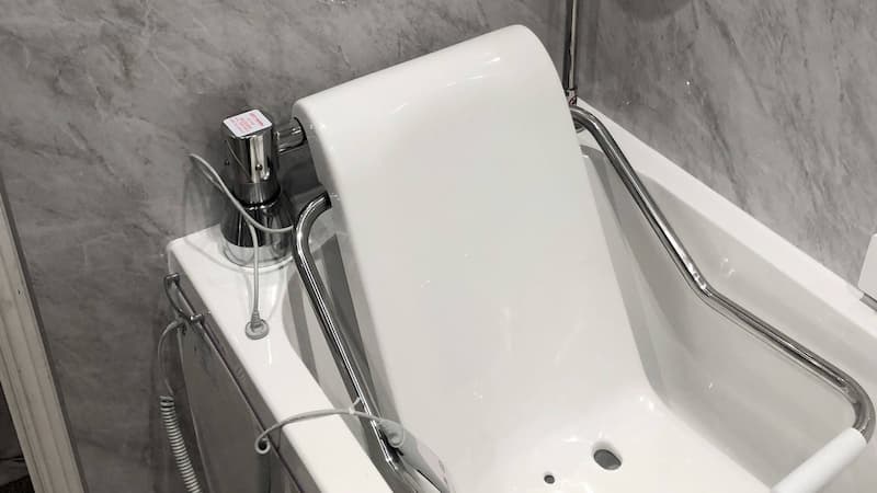 Grey bathroom, bath with white seat
